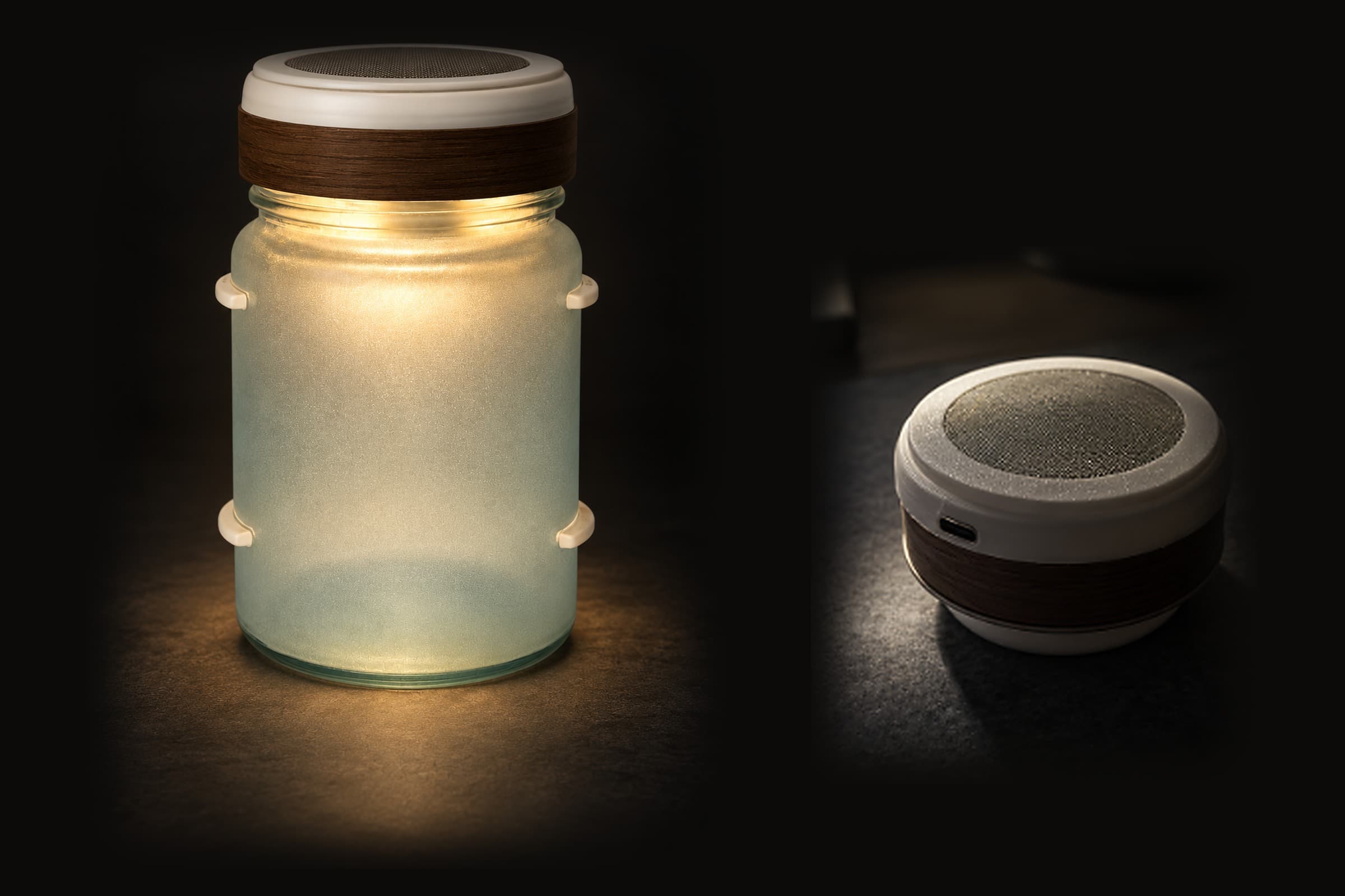 The jar speaker lit warm on a dark surface, with the puck module beside it